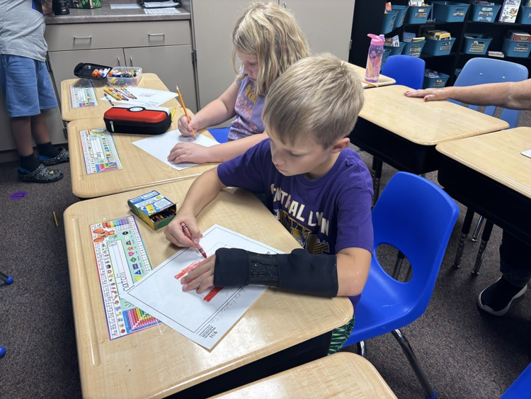 students sitting at their desks and writing their hero letters 