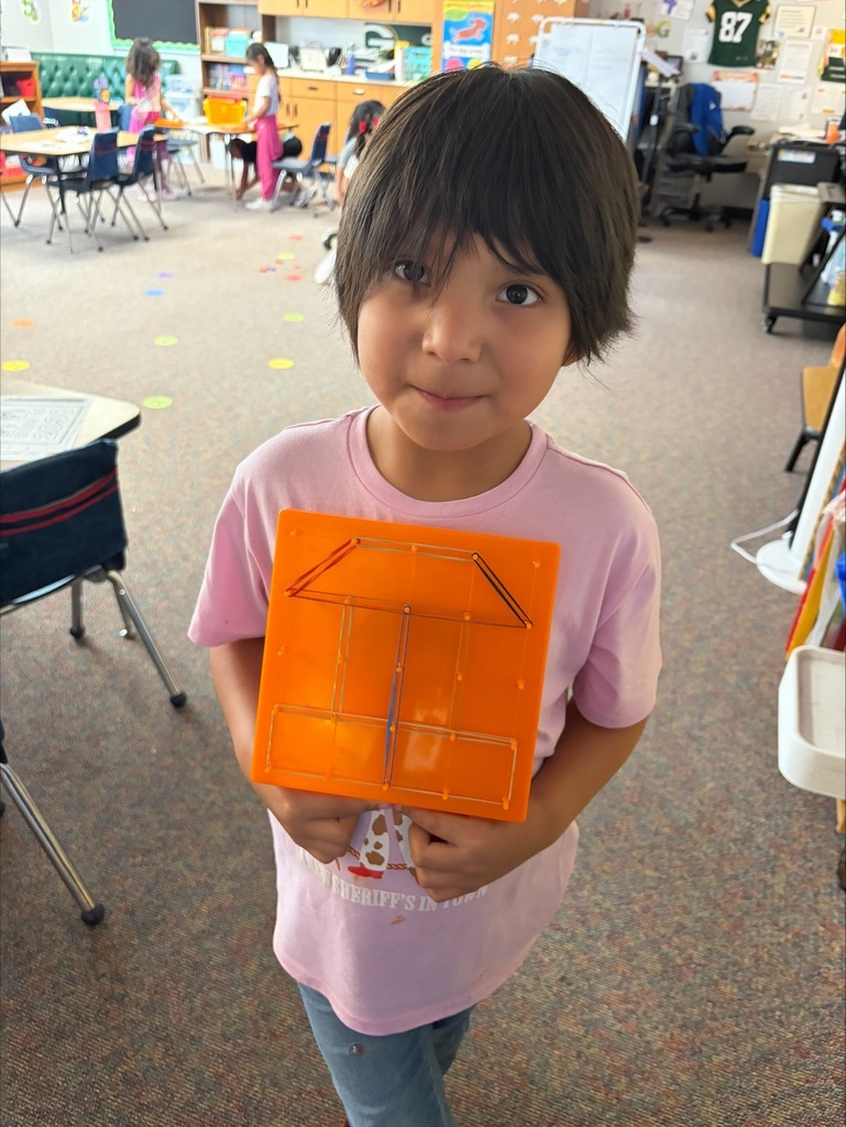 A students showing her design on a geoboard.