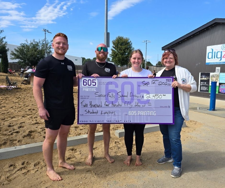 605 Paint owners Dan, Kyle, and Paige stand next to Child Nutrition Coordinator Gay Anderson holding a big donation check for $2,450 raised at their annual volleyball tournament