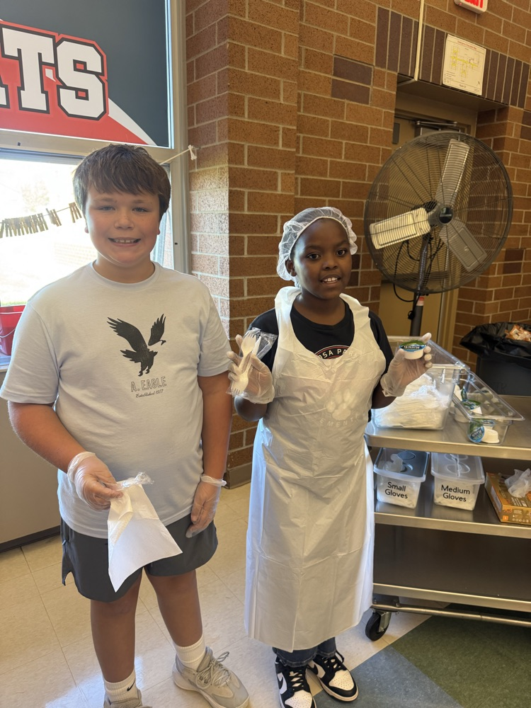 two boys handing out napkins and condiments 