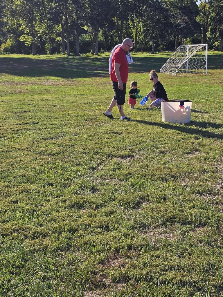 A mom, dad and boy playing in the field
