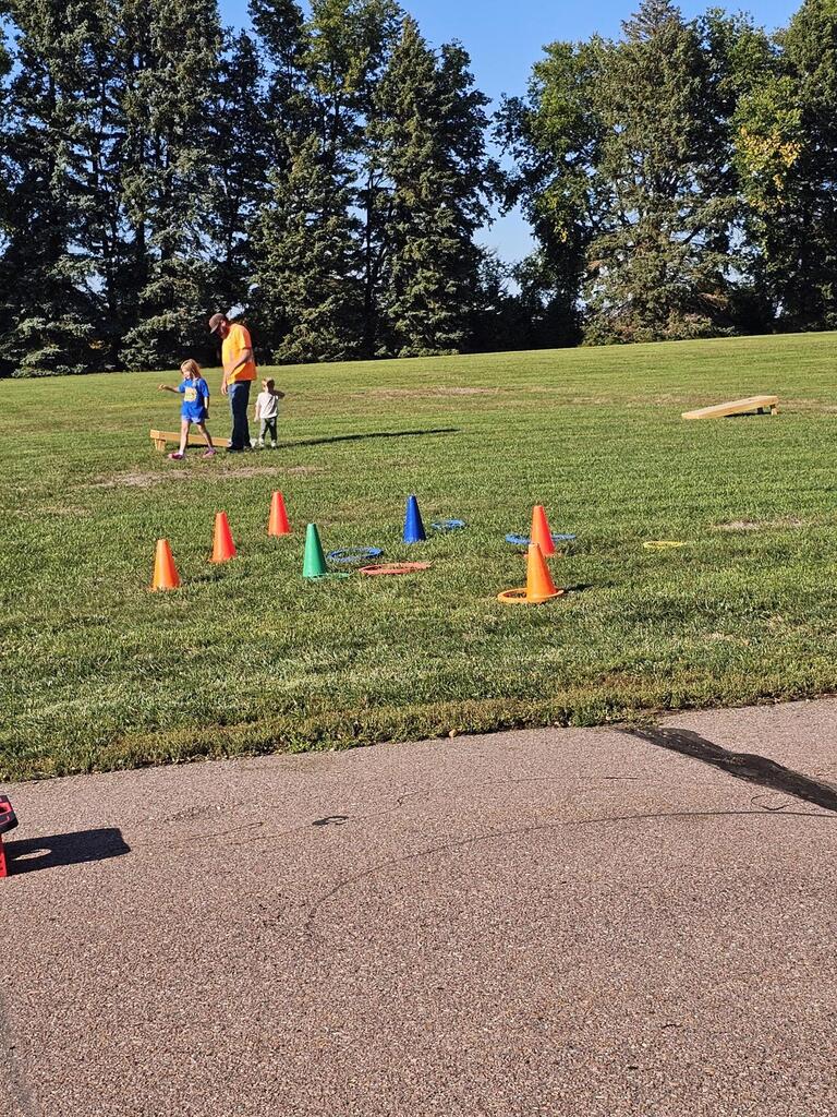 a dad with a girl and boy playing on the field