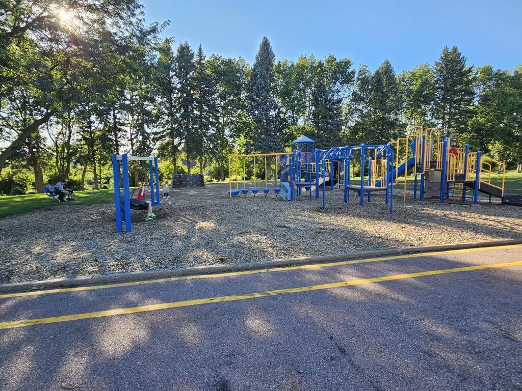 the playground, a boy in swinging on the tire swing