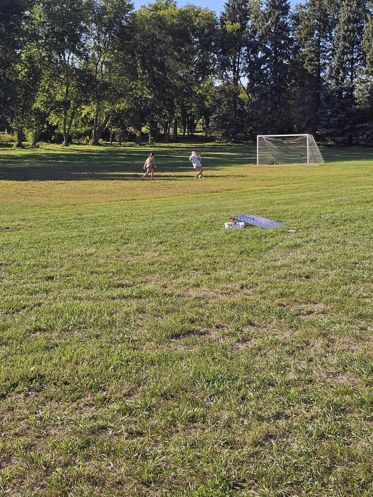 2 girls playing soccer on the field