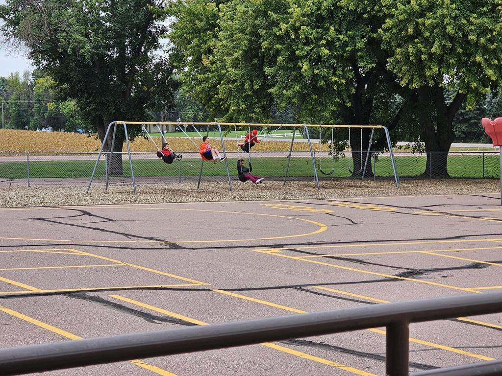 4 kids swinging on the swings