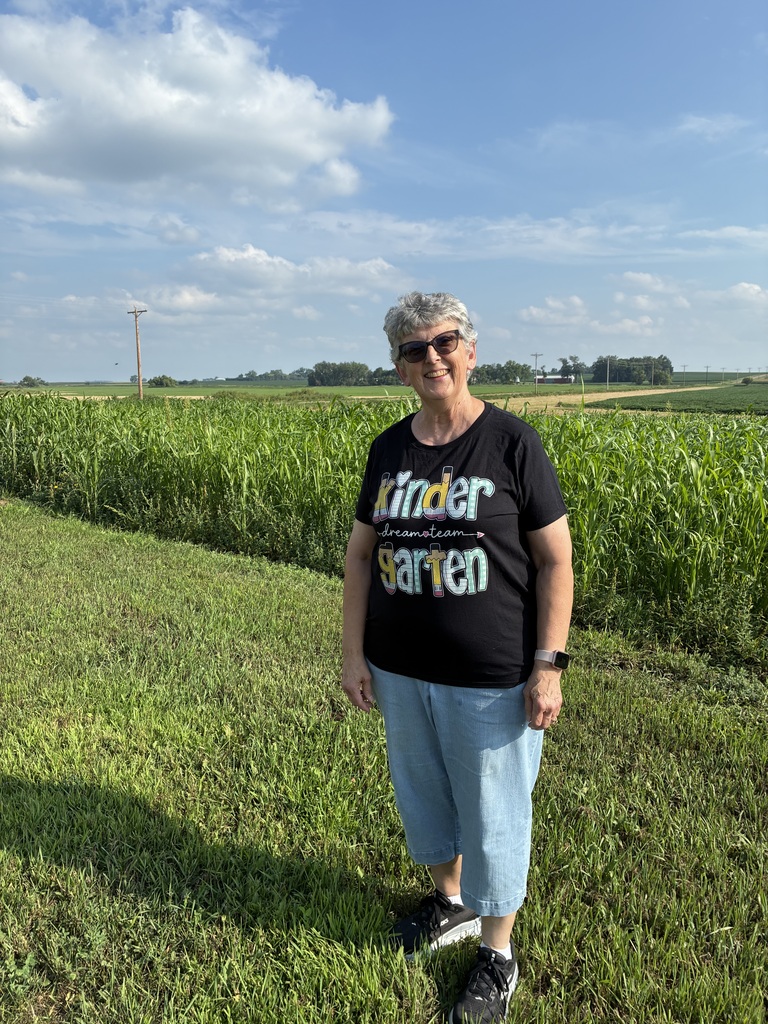 Mrs. Eilertson outside by a corn field.