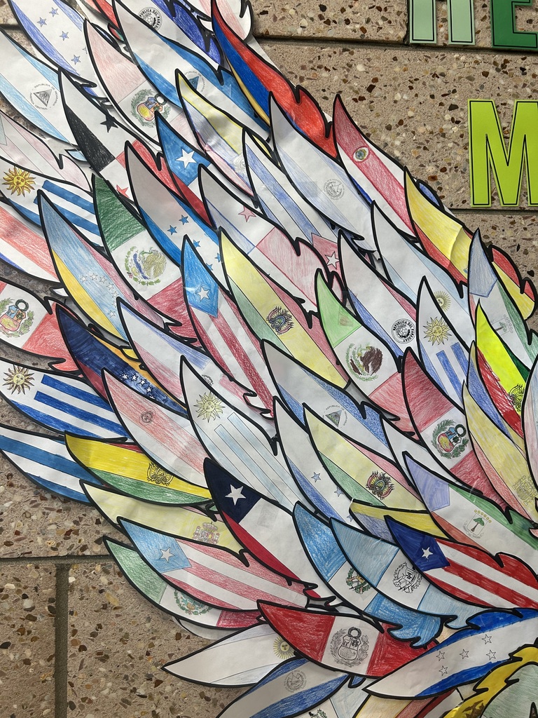 Close-up of one wing in the display, showing overlapping paper feathers hand-colored with the flags of Mexico, Puerto Rico, Chile, Uruguay, Peru, Paraguay, Bolivia, Guatemala, Spain, and other Spanish-speaking countries.
