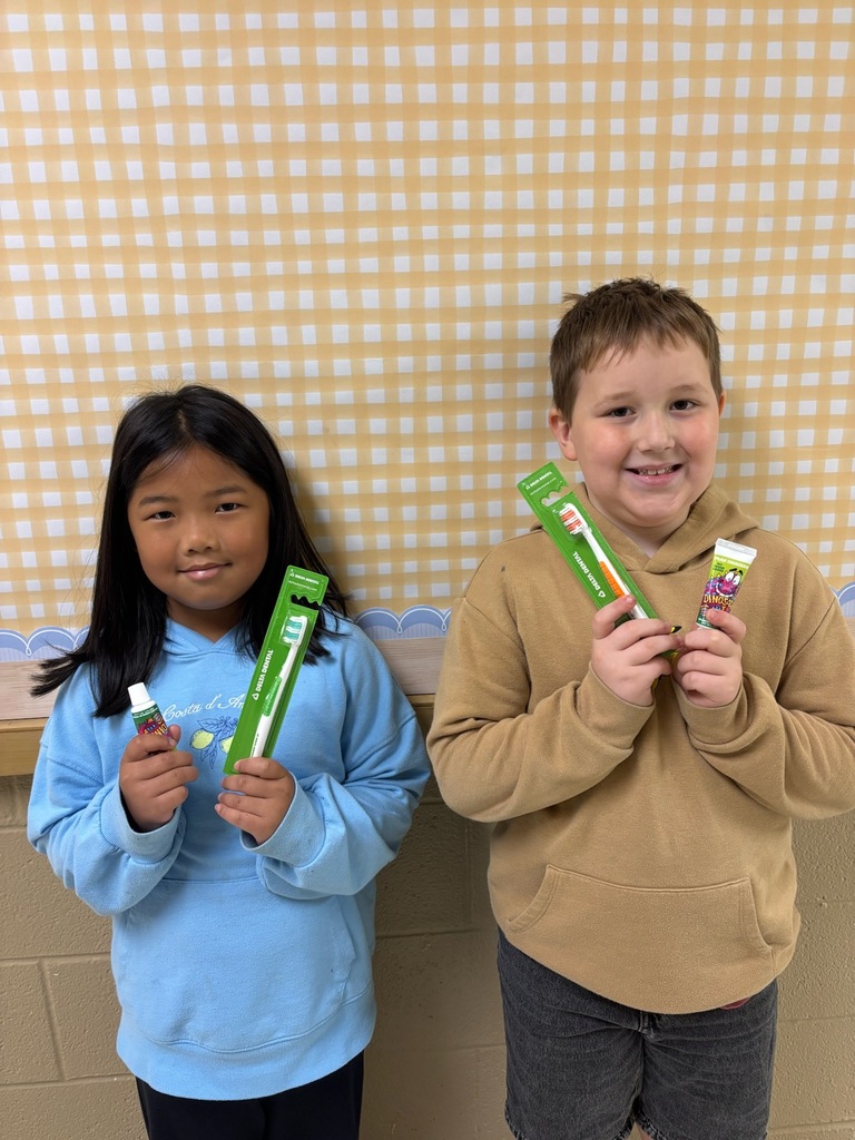 students holding a toothbrush and tooth paste