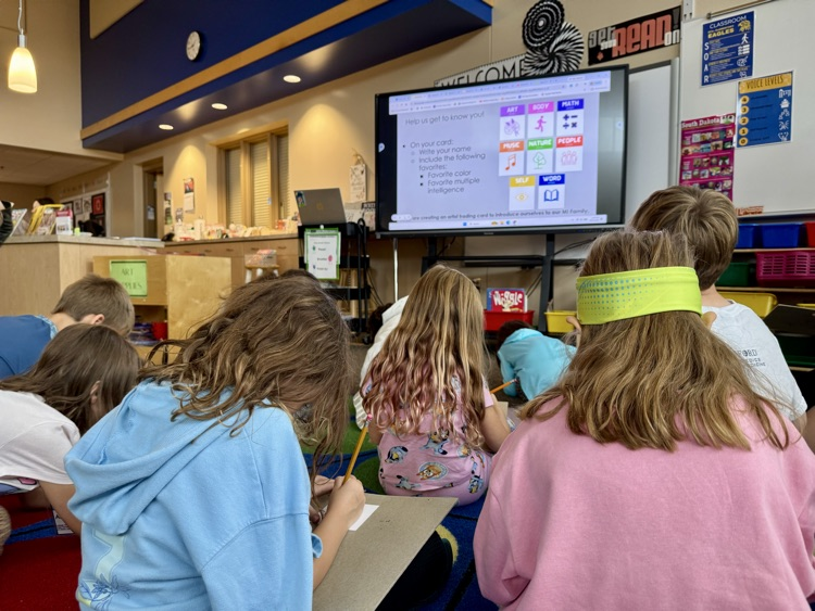 a group of students sitting in front of a view board