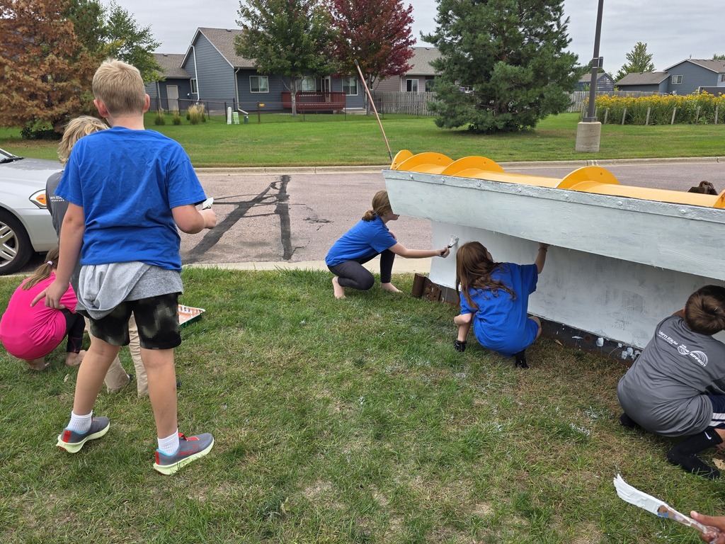 Students working together to paint the plow