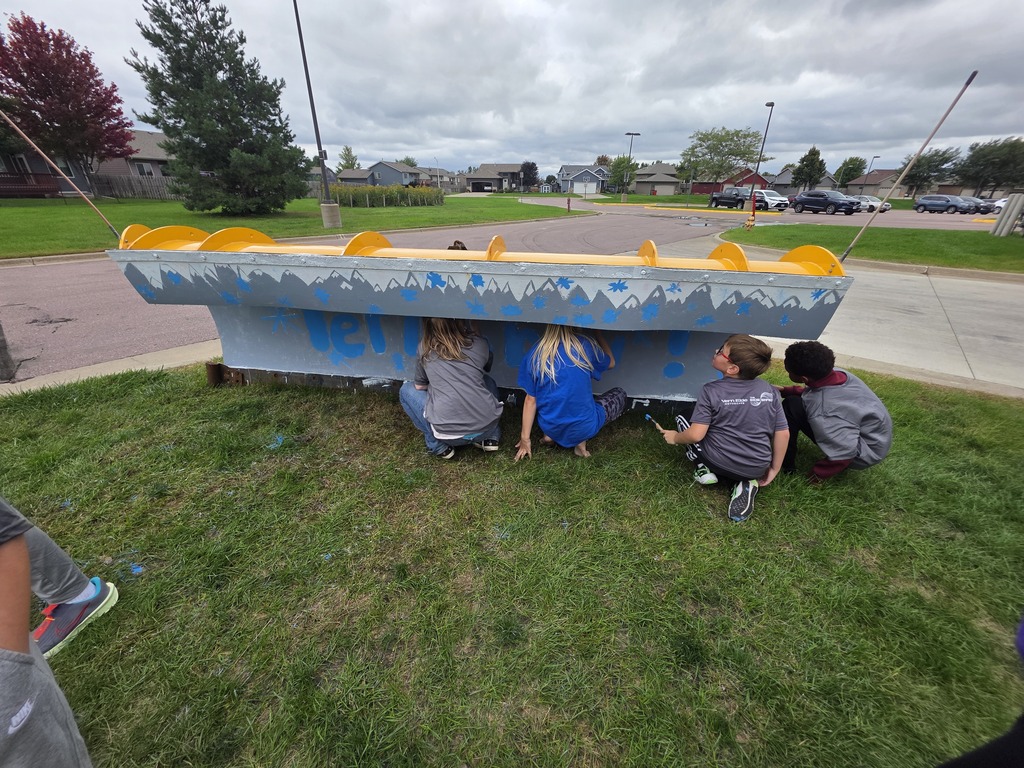 Students working together to paint the plow 