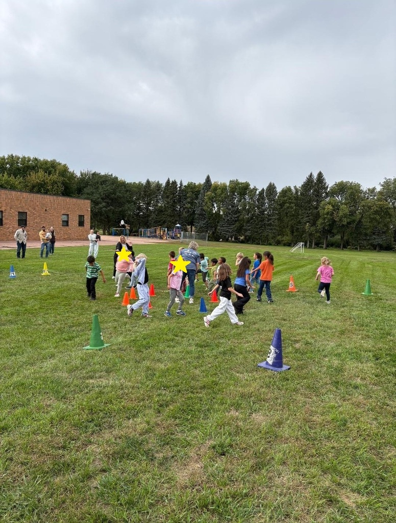 Kinder and 1st grade students walking around in a circle