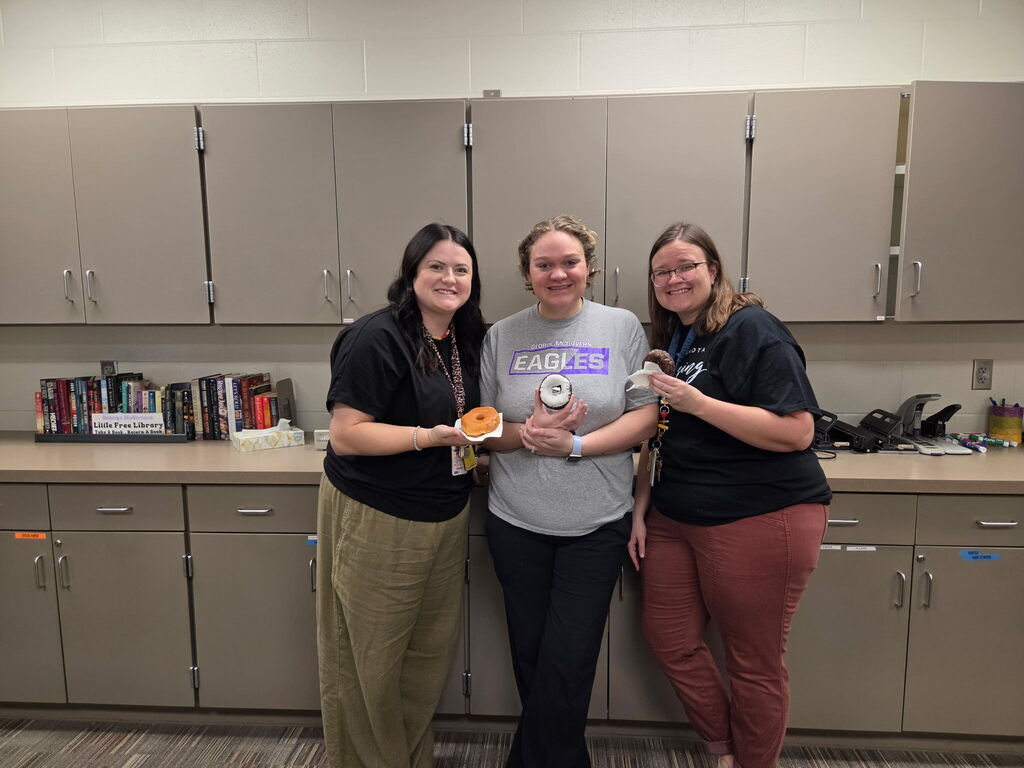 Three staff members with their doughnuts. 