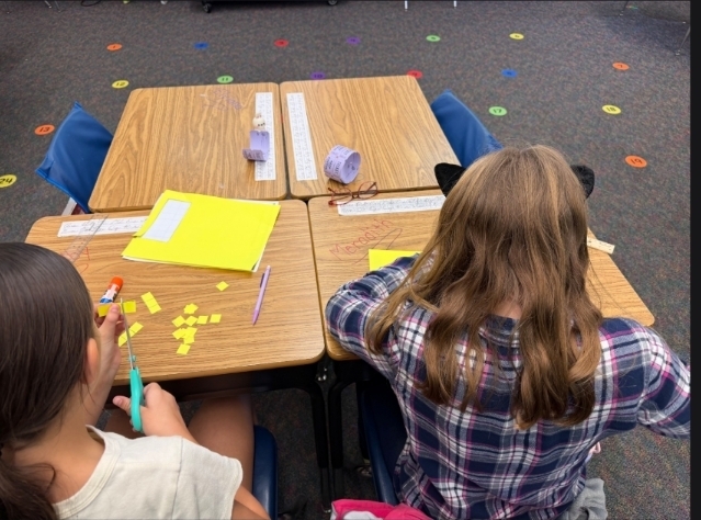 2 girls cutting out squares