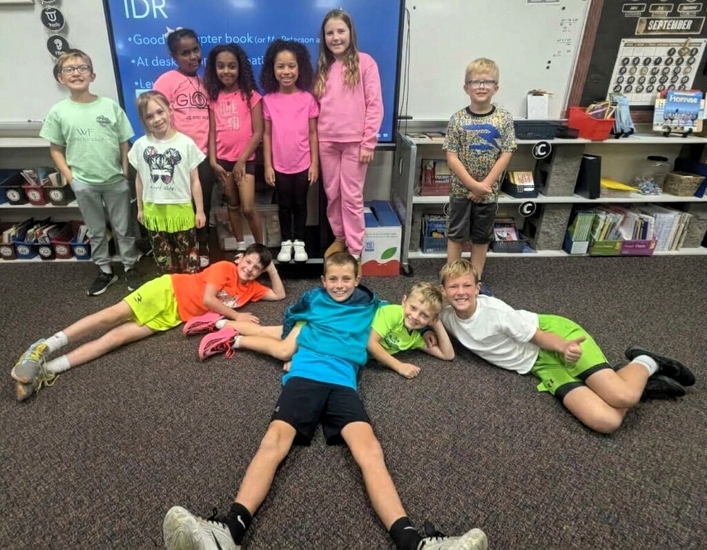 Students smiling while wearing bright neon colors to celebrate Monday's homecoming week dress up day, which was Neon Day.
