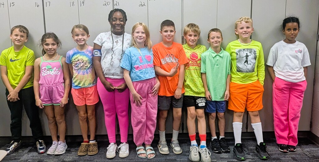 Students smiling while wearing bright neon colors to celebrate Monday's homecoming week dress up day, which was Neon Day.