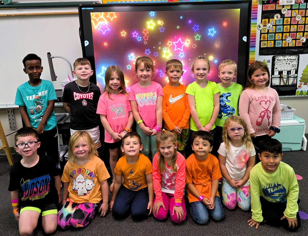Students smiling while wearing bright neon colors to celebrate Monday's homecoming week dress up day, which was Neon Day.