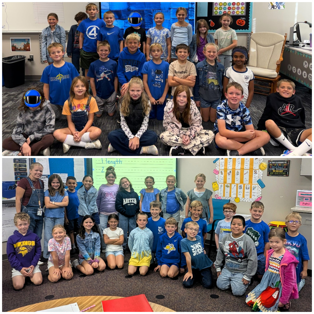 Classroom of students dressed in denim or blue smiling for a group picture.