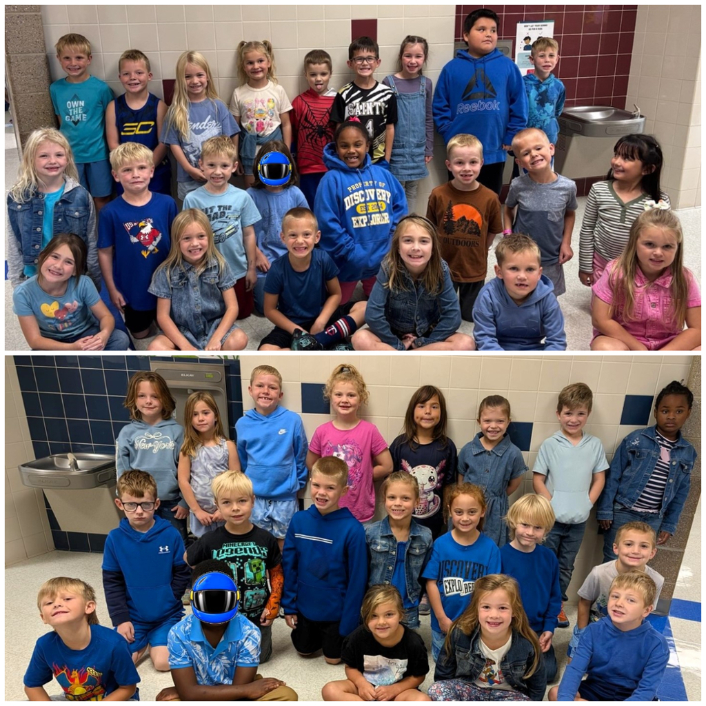 Classroom of students dressed in denim or blue smiling for a group picture.