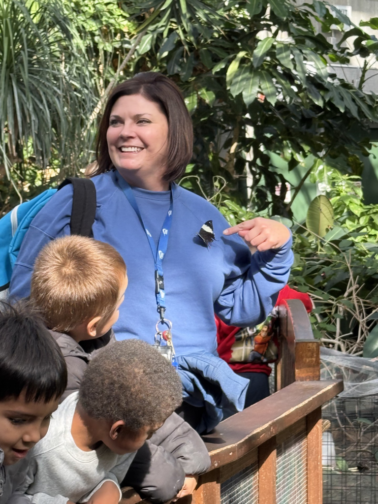 An adult with a butterfly on their sweatshirt