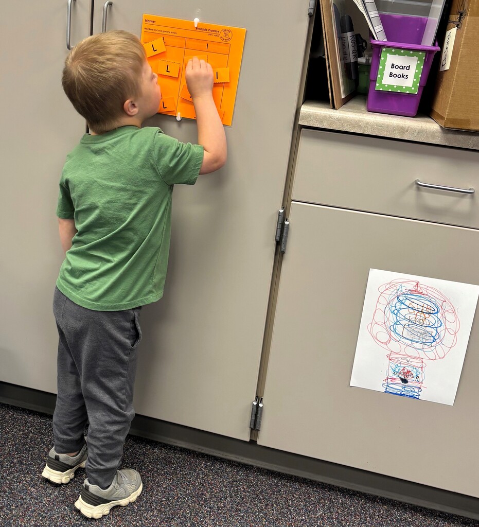 Student standing next to closet sorting upper and lower case letters. 