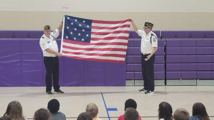 2 men hold United States flag 