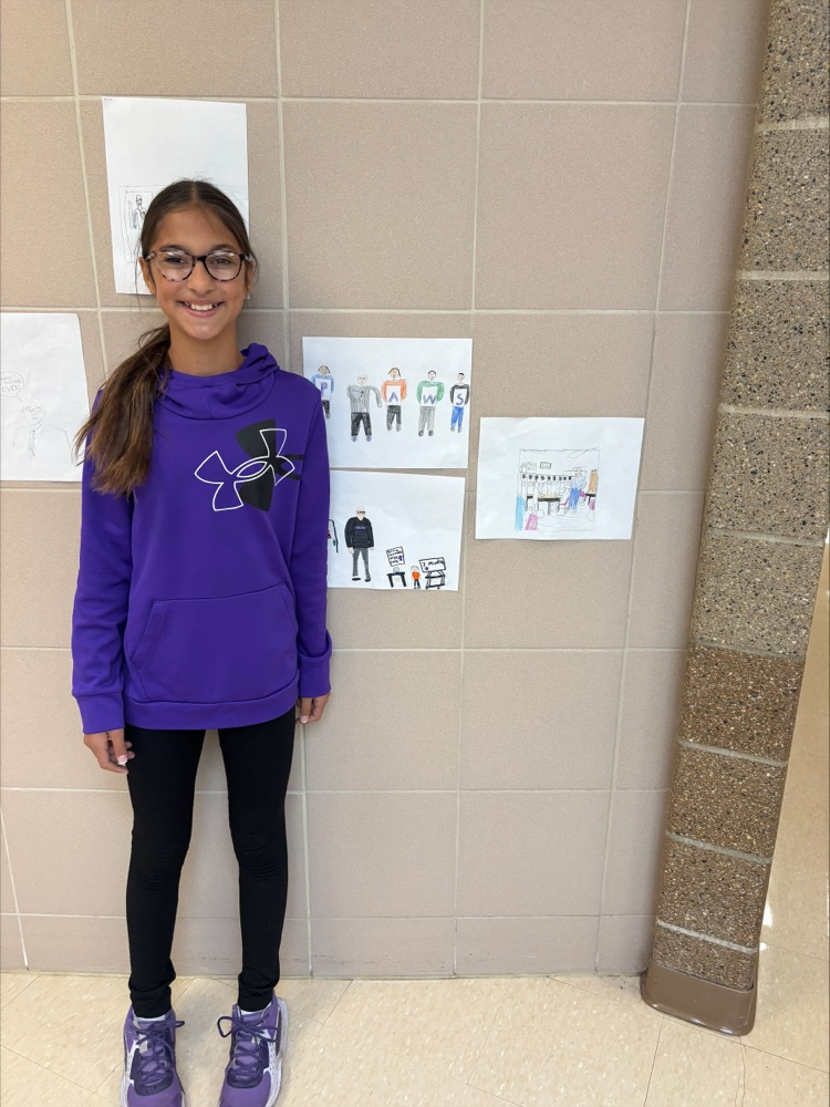 student standing next to the picture she drew of our principal 