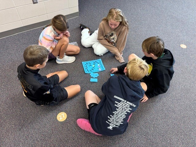In music class, Classroom 405 students are playing a board game to practice reading notes that move by step, skip, or repeat.