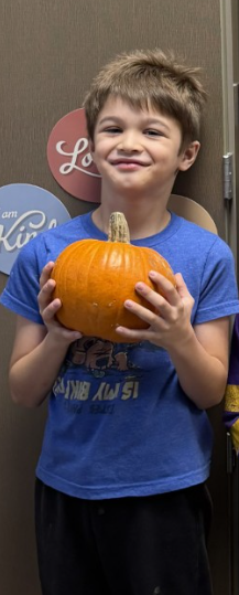 Student stands excited after picking out a pumpkin!