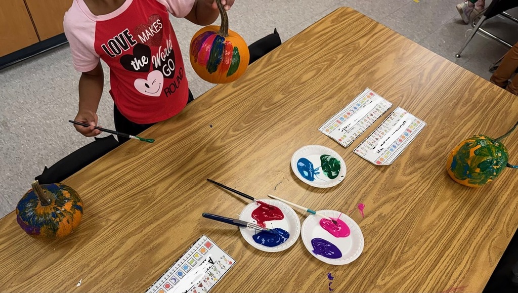 A student painting a pumpkin