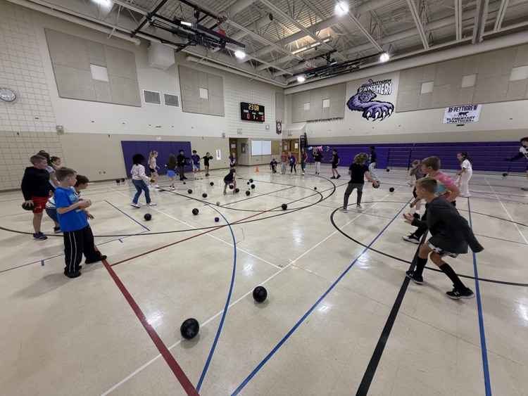 students playing a game of kick ball in the gym 