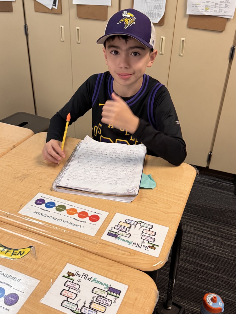 boy writing a story at his desk 
