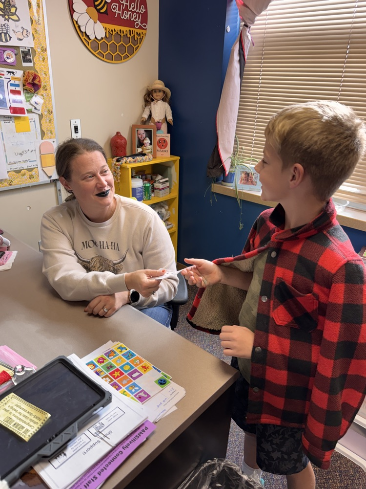 student turning in his PAWS ticket to his teacher 