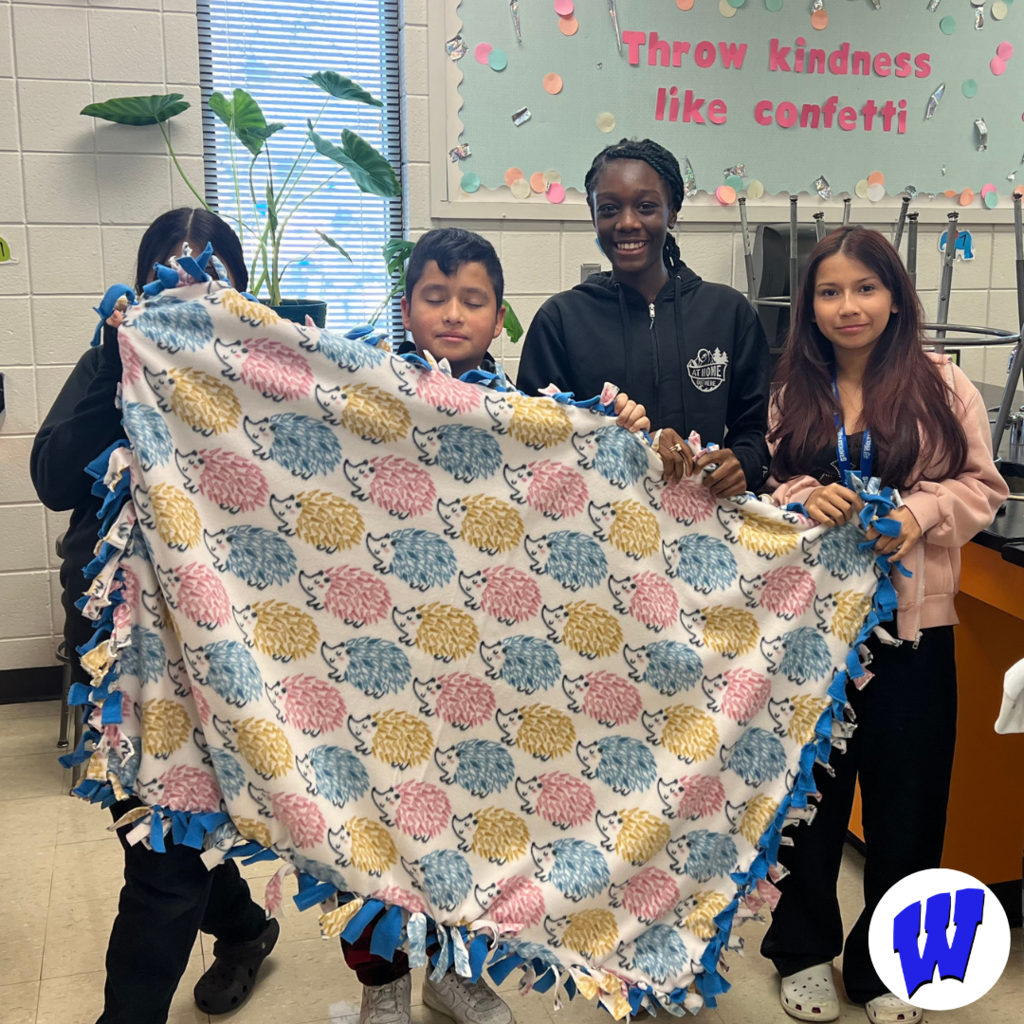 Whittier students with a completed blanket for Project Warm-Up
