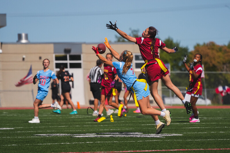 Roosevelt and Lincoln High School Girls Flag Football player jump to catch a football at the very first Girls Flag Football Jamboree event at Howard Wood Field