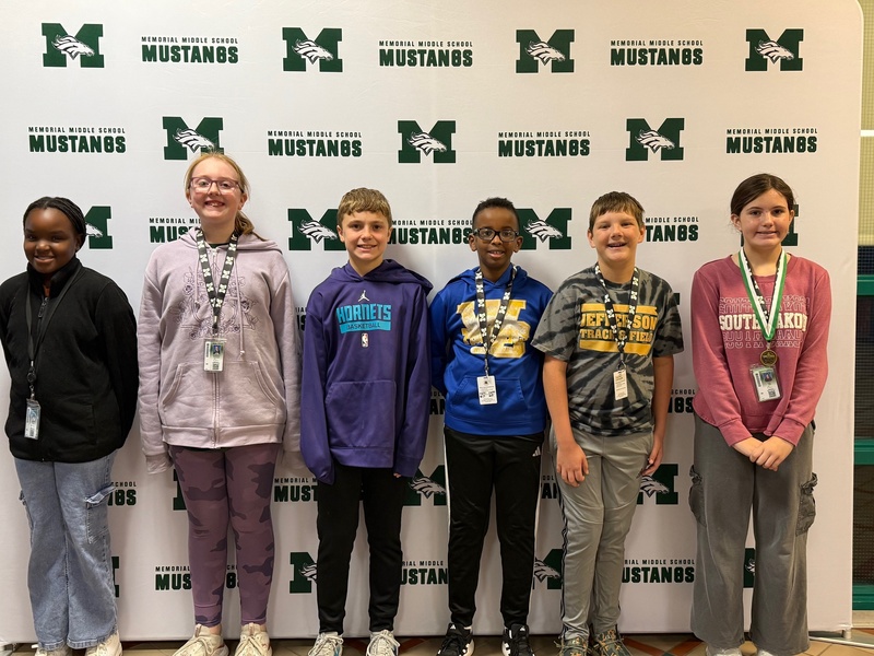 Six smiling 6th-grade students pose together to celebrate being named Students of the Month.