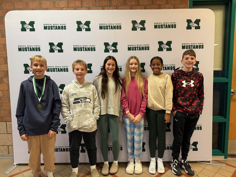 Six smiling 7th-grade students pose together to celebrate receiving Student of the Month