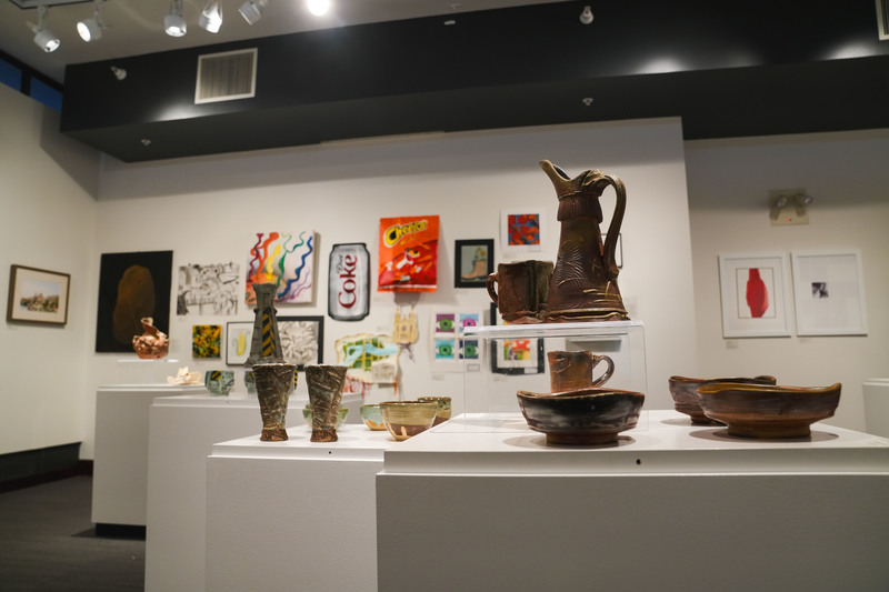 ceramic bowls and challaces displayed on a white case as part of an art exhibit 