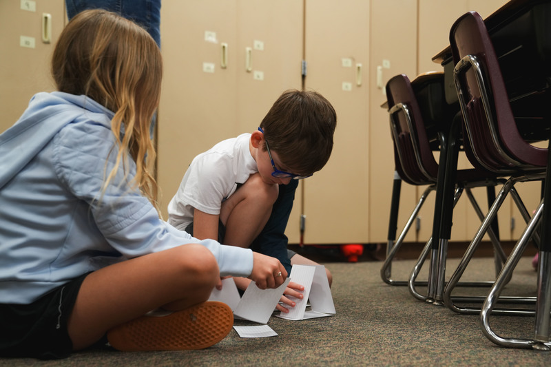 Students build models with paper cards.