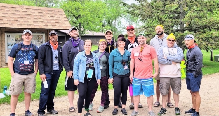 Multiple adults standing and smiling at the camera.