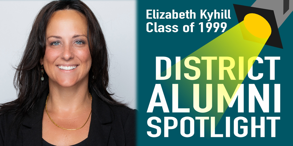 Graphic titled “District Alumni Spotlight” featuring Elizabeth Kyhill, Class of 1999. On the left is a professional portrait of Elizabeth Kyhill smiling, wearing a black blazer and gold necklace, with a light gray background. On the right, text reads “Elizabeth Kyhill, Class of 1999” above a yellow spotlight shining onto the words “District Alumni Spotlight.”