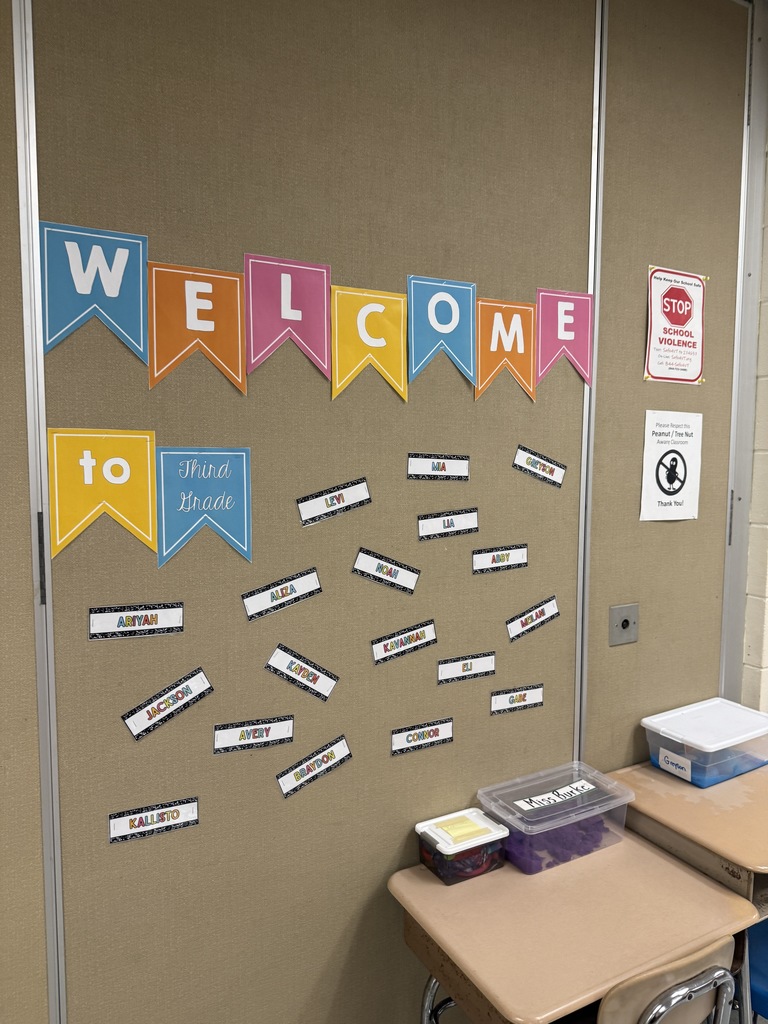 Bulletin board with colorful “Welcome to Third Grade” banner and student name tags.