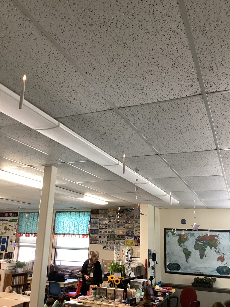 Ceiling view of floating candles hanging above a classroom.