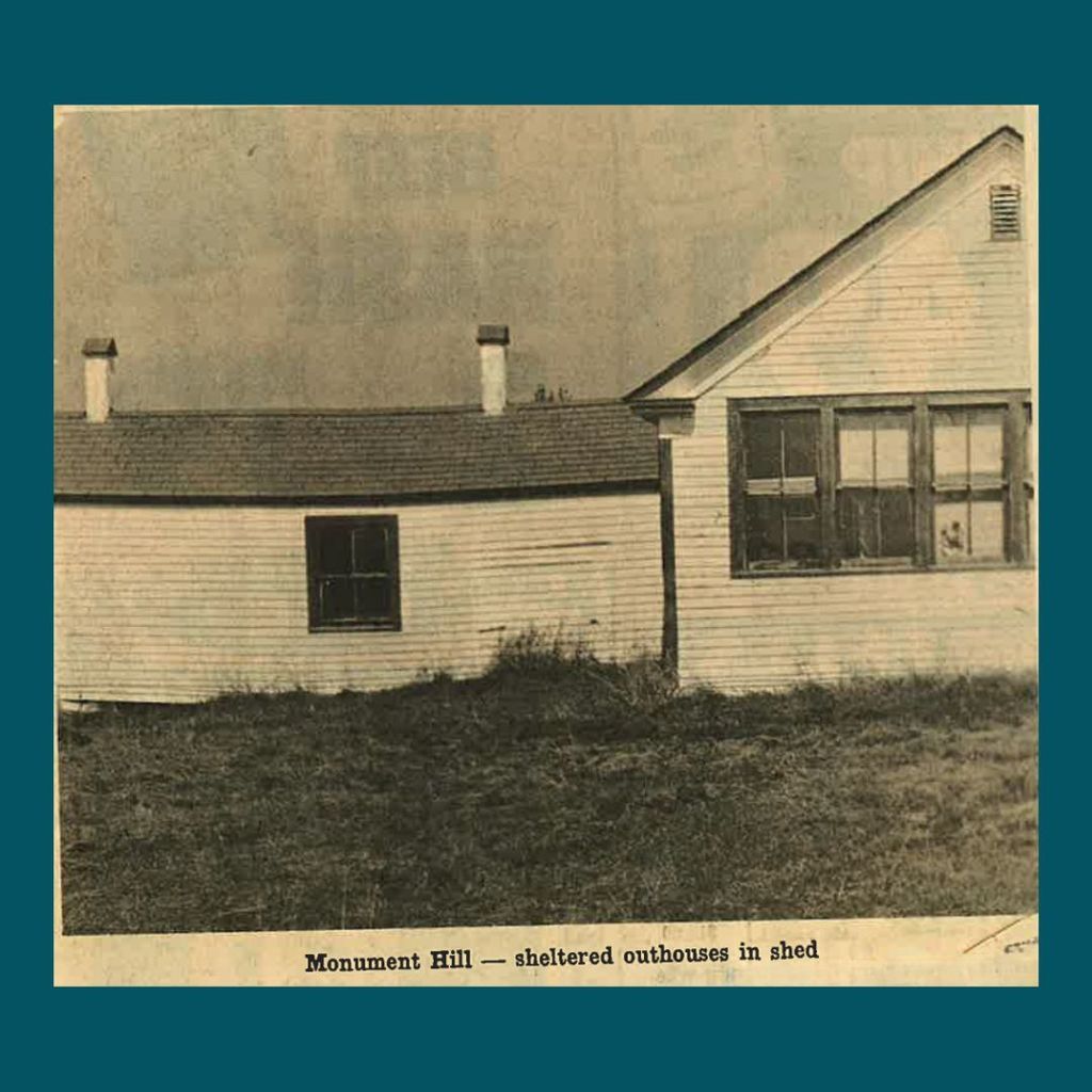 Black and white photo of Monument Hill School with a shed that sheltered outhouses attached to the building.