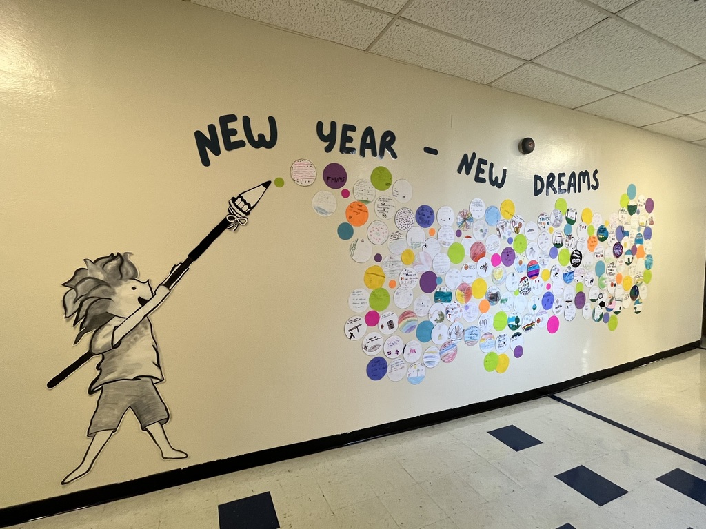 School hallway mural with the words “New Year – New Dreams.” A painted child holds a large paintbrush pointing toward hundreds of colorful paper circles on the wall, each displaying student hopes and dreams for the school year.