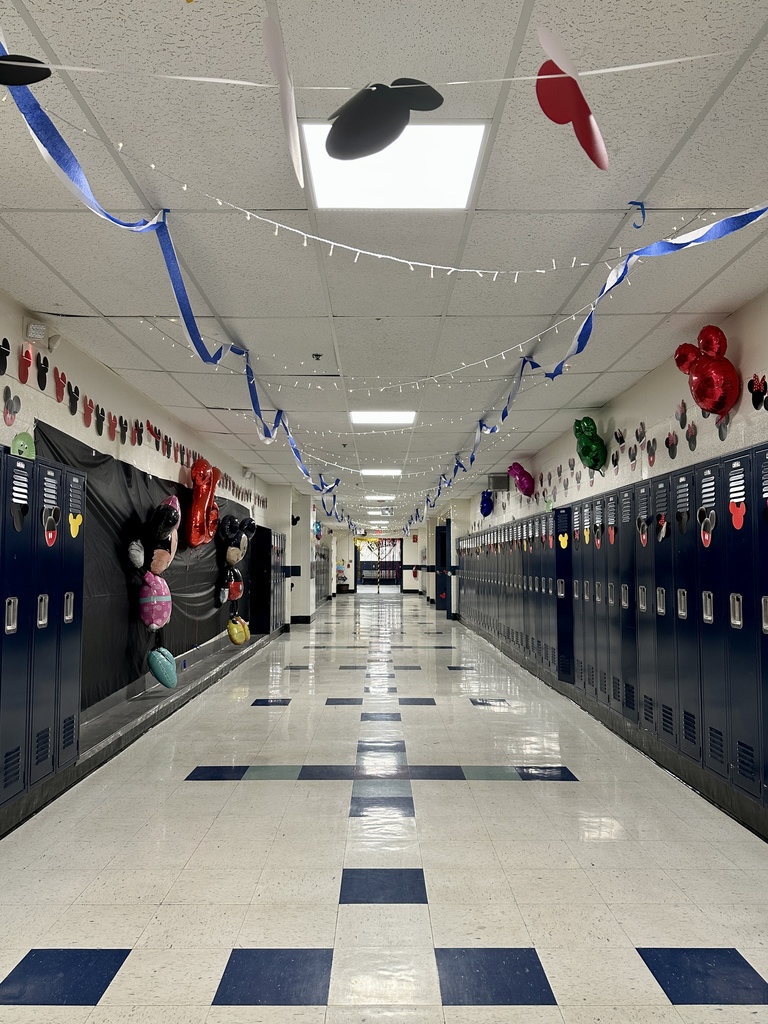 Hallway photo: A school hallway decorated with blue streamers, string lights, and cutout Mickey Mouse heads above rows of lockers.