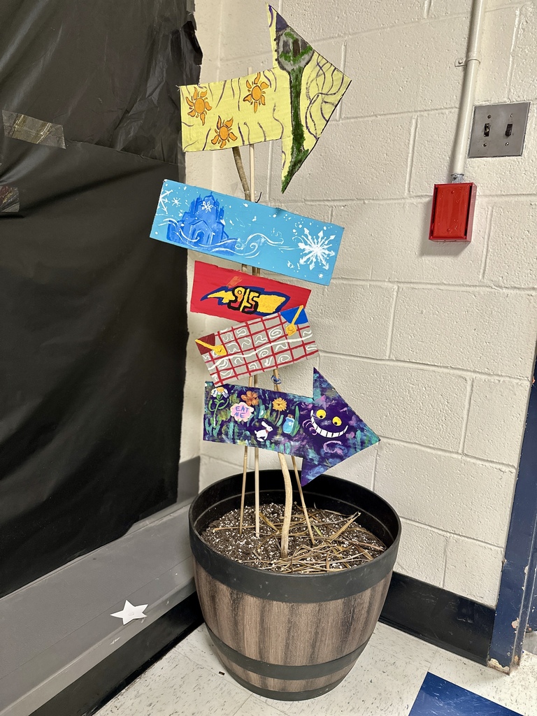 Colorful painted arrows in a barrel of dirt, pointing in different directions with Disney-themed designs like suns, snowflakes, and the Cheshire Cat.