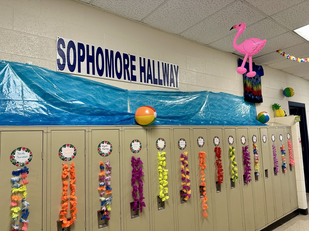 Lockers decorated with leis, beach balls, and a large “Sophomore Hallway” sign above blue ocean-themed paper.