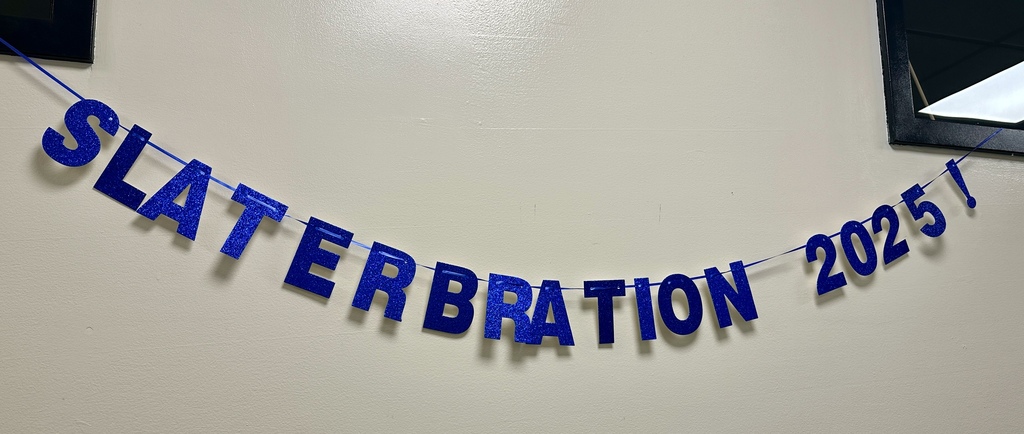 Blue glitter letters on a wall strung together to read “Slaterbration 2025!