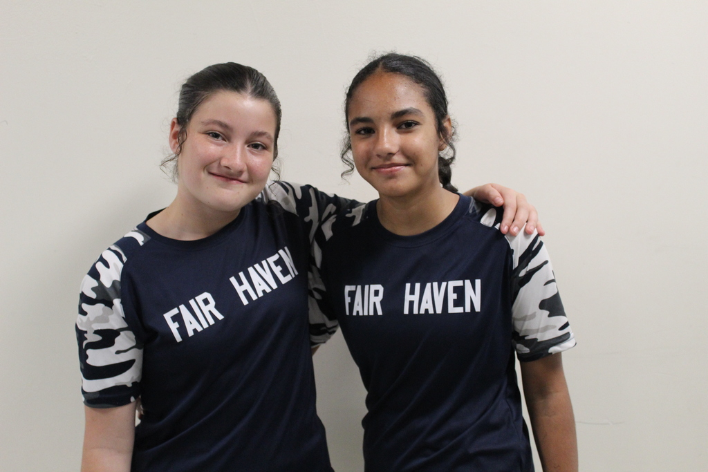 Two students wearing navy blue shirts that say "Fair Haven," smiling side by side.